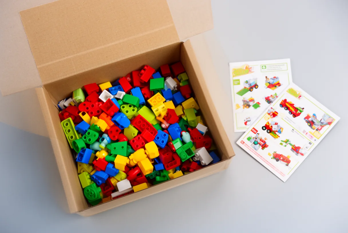 Boîte de Lego ouverte avec des briques colorées et un livret d'instructions fermé